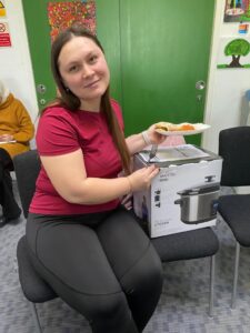A woman receiving her slow cooker as part of the FareShare Greater Manchester Slow Cooker Project