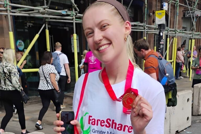Former volunteer, Isobel, with her race medal after running in the Great Manchester Run 10K