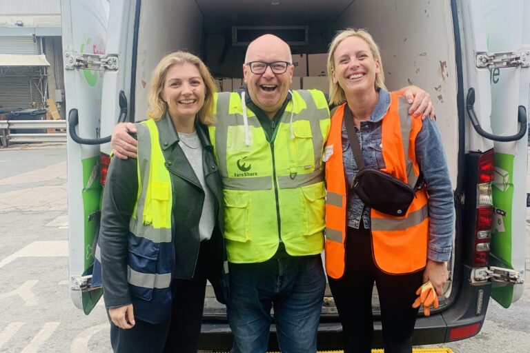 N Brown volunteers with FareShare GM driver by delivery van, smiling
