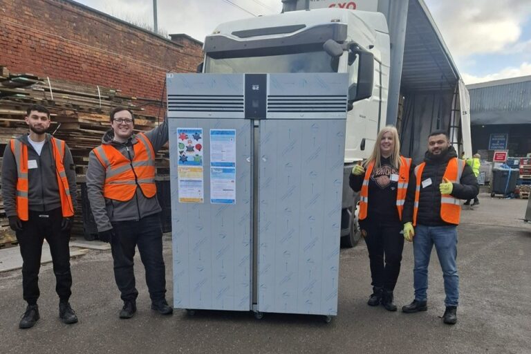 large fridge in goods yard with four corporate volunteers