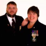 Image shows Chris Wright and Claire Squires, founders of Trafford Veterans wearing smart clothing and medals smiling at the camera